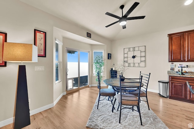 dining area with baseboards, light wood-type flooring, and a ceiling fan