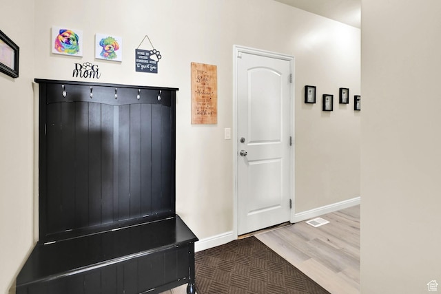 mudroom featuring visible vents, baseboards, and wood finished floors