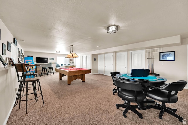 game room with a textured ceiling, carpet flooring, and pool table