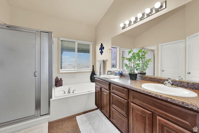 full bathroom featuring a bath, a sink, a shower stall, double vanity, and lofted ceiling