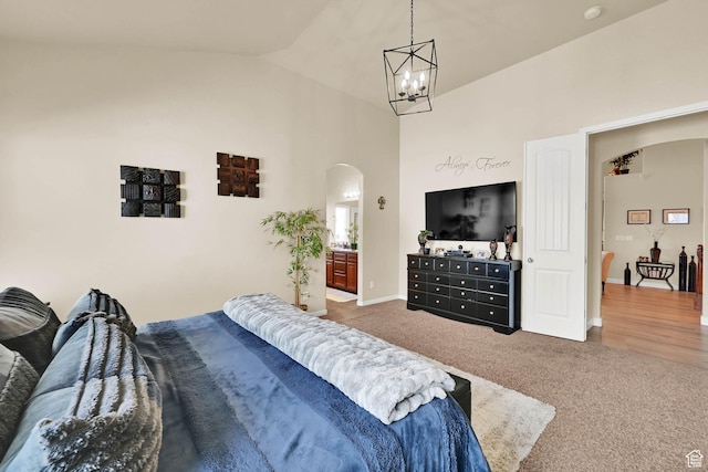 bedroom featuring baseboards, arched walkways, a notable chandelier, carpet floors, and high vaulted ceiling