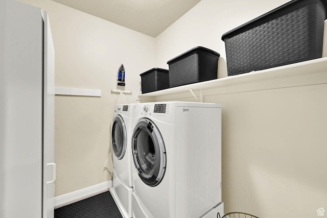 clothes washing area featuring washer and dryer, laundry area, and baseboards