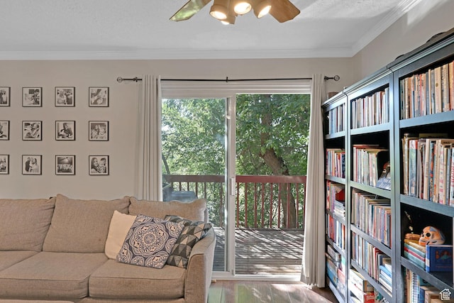 interior space with ornamental molding, a ceiling fan, and wood finished floors