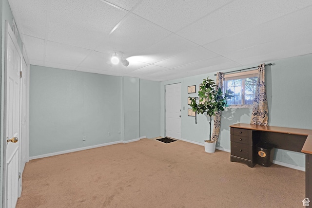 interior space featuring a paneled ceiling and baseboards