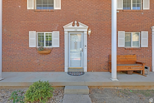 entrance to property featuring brick siding
