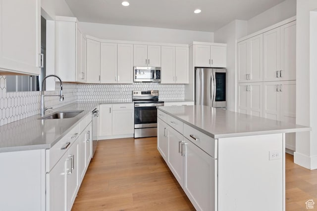 5648 S Adobe Sun Dr, St George, UT 84790 - kitchen featuring light countertops, a center island, backsplash, appliances with stainless steel finishes, and a sink