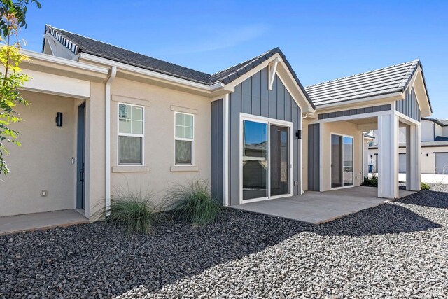 5648 S Adobe Sun Dr, St George, UT 84790 - rear view of property featuring a patio, a tiled roof, and board and batten siding
