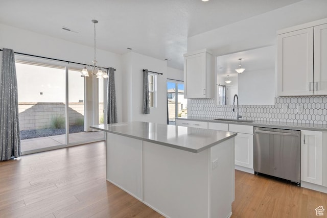 5648 S Adobe Sun Dr, St George, UT 84790 - kitchen featuring white cabinetry, a kitchen island, dishwasher, a sink, and backsplash
