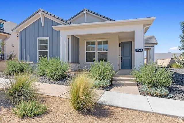 5648 S Adobe Sun Dr, St George, UT 84790 - bungalow-style house featuring a tiled roof, stone siding, stucco siding, and board and batten siding