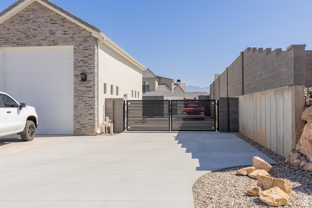 1624 W Chandler Dr, St George, UT 84770 - view of side of home with a gate, driveway, and stone siding