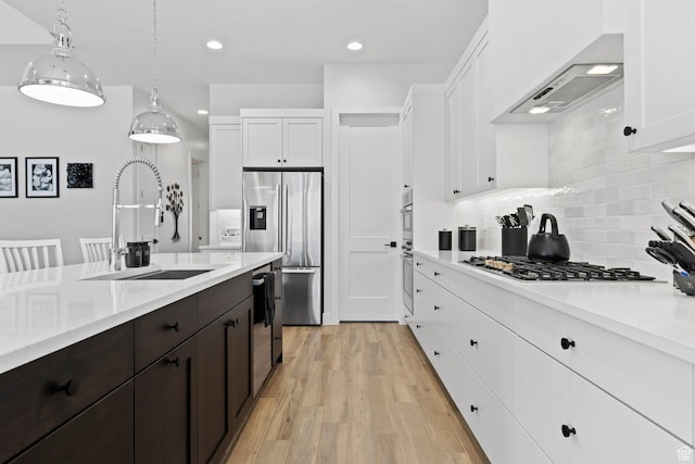 1624 W Chandler Dr, St George, UT 84770 - kitchen with stainless steel appliances, wall chimney exhaust hood, white cabinets, decorative backsplash, and recessed lighting