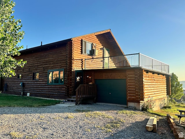 2947 S Chukar Dr, Garden City, UT 84028 - view of front of home with log siding, a balcony, driveway, and a garage