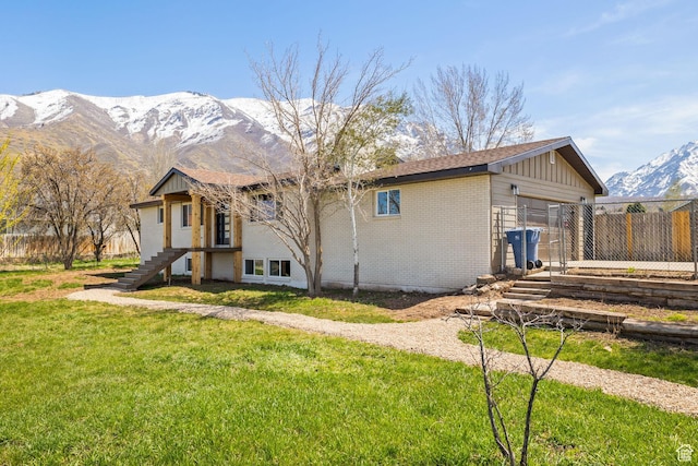 205 S Highland Dr, Santaquin, UT 84655 - back of house featuring a mountain view, stairway, brick siding, a yard, and fence