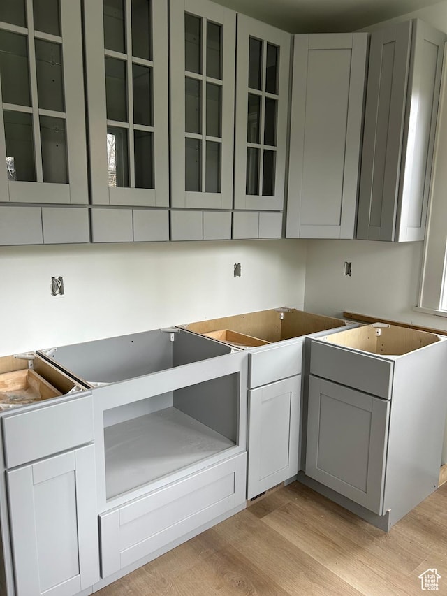 1161 E Bueno Ave, Salt Lake City, UT 84102 - kitchen featuring light wood finished floors, glass insert cabinets, and gray cabinets