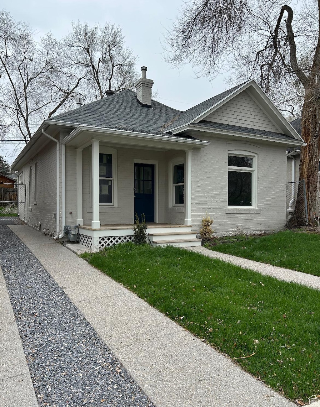 1161 E Bueno Ave, Salt Lake City, UT 84102 - bungalow-style home with a porch, a chimney, fence, brick siding, and a front yard