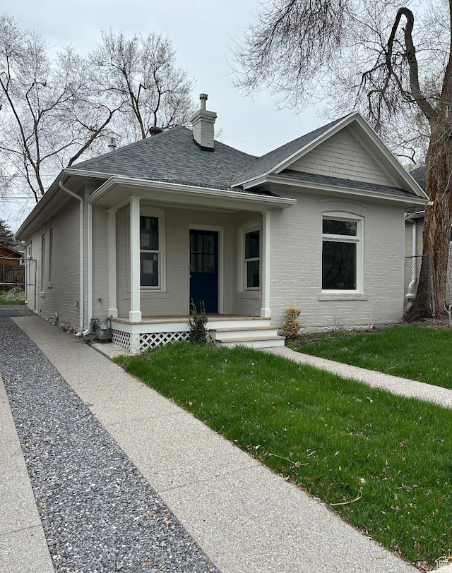 1161 E Bueno Ave, Salt Lake City, UT 84102 - bungalow-style home with a porch, a chimney, fence, brick siding, and a front yard