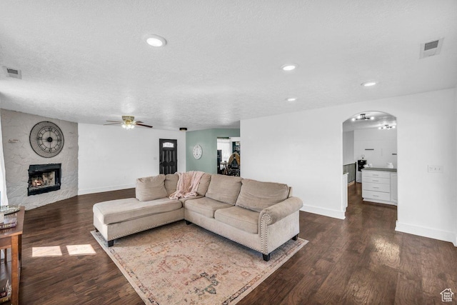 1112 S Granada Royale, Washington, UT 84780 - living area featuring baseboards, arched walkways, dark wood-style flooring, a ceiling fan, and a large fireplace
