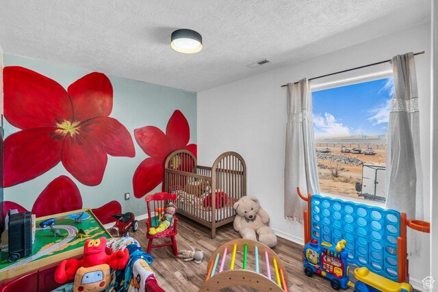 1112 S Granada Royale, Washington, UT 84780 - rec room featuring a textured ceiling, wood finished floors, baseboards, and visible vents