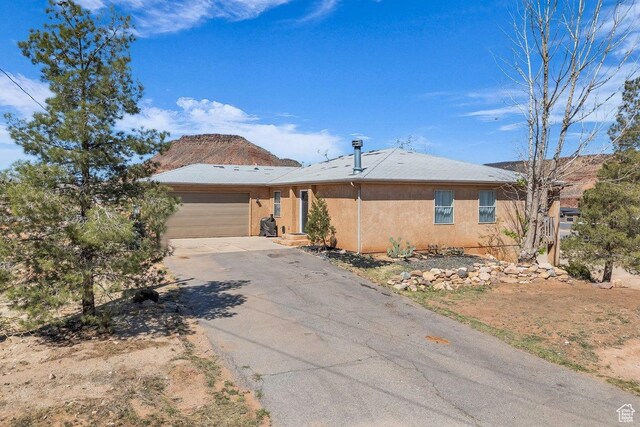 1112 S Granada Royale, Washington, UT 84780 - ranch-style home with aphalt driveway, stucco siding, and an attached garage