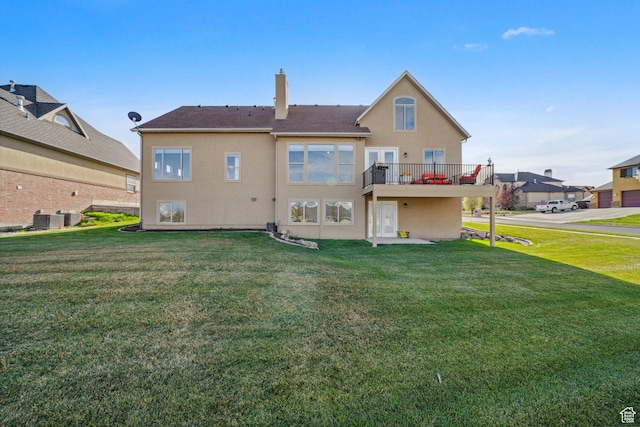 back of property featuring cooling unit, a yard, stucco siding, and a chimney