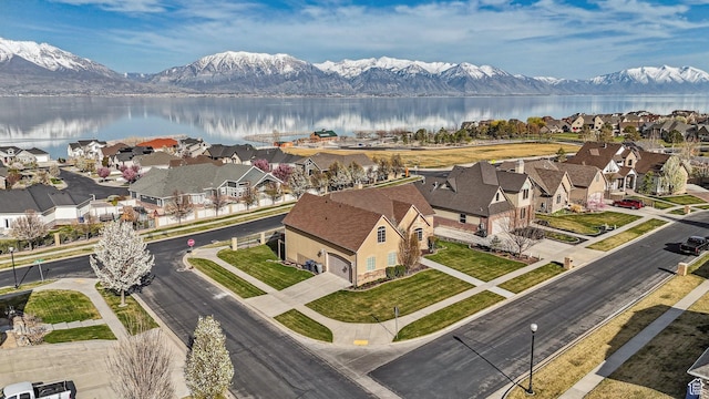drone / aerial view featuring a water and mountain view and a residential view