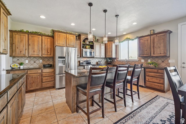 kitchen featuring a kitchen bar, recessed lighting, stainless steel appliances, brown cabinets, and backsplash