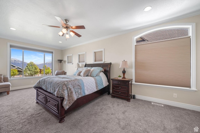 bedroom featuring visible vents, baseboards, ceiling fan, crown molding, and carpet flooring