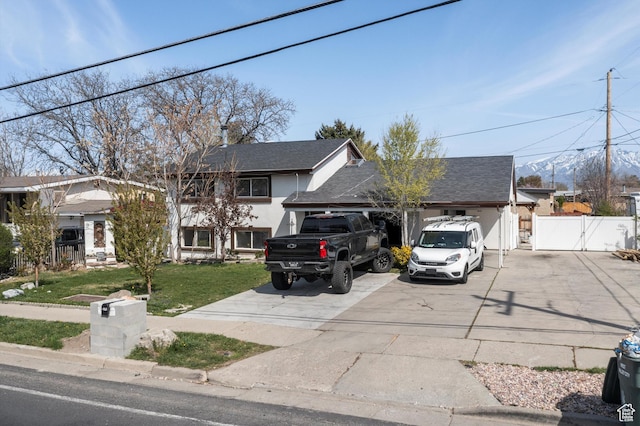 view of front facade featuring stucco siding, a gate, a front lawn, fence, and a shingled roof