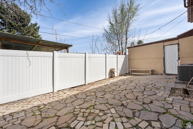 view of patio with central AC and fence