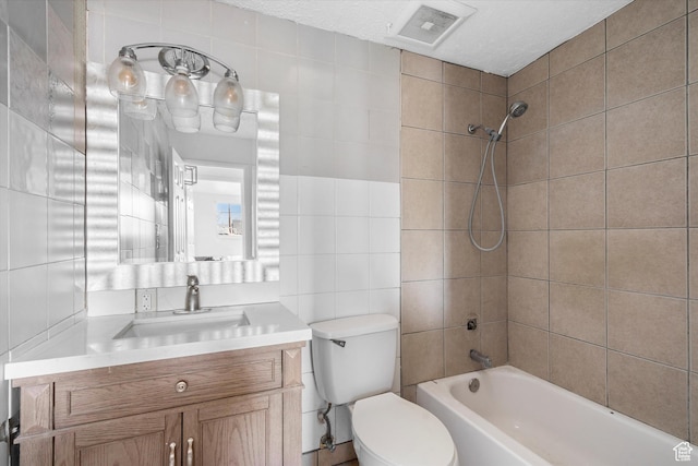 full bathroom with visible vents, toilet, tile walls, bathtub / shower combination, and vanity