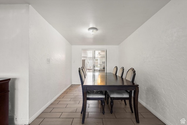 dining room featuring baseboards and a textured wall