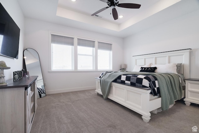 bedroom with light carpet, recessed lighting, visible vents, and a tray ceiling