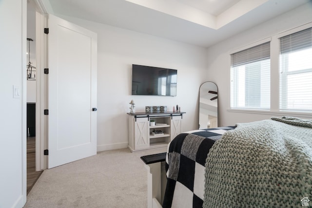 bedroom featuring light colored carpet and baseboards