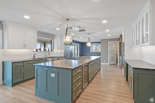 816 E 16th Ave, Salt Lake City, UT 84103 - kitchen featuring dark countertops, white cabinets, a center island, and tasteful backsplash