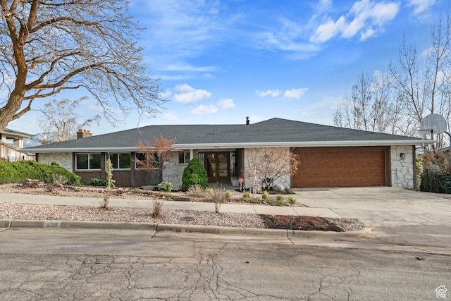 816 E 16th Ave, Salt Lake City, UT 84103 - view of front of home featuring stone siding, roof with shingles, a chimney, concrete driveway, and an attached garage
