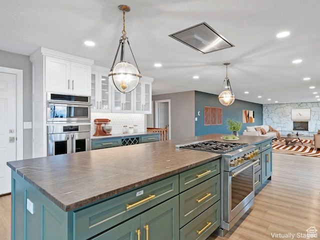 816 E 16th Ave, Salt Lake City, UT 84103 - kitchen featuring green cabinetry, appliances with stainless steel finishes, light wood-style floors, white cabinetry, and a kitchen island