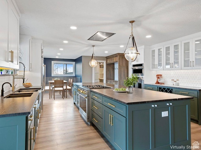 816 E 16th Ave, Salt Lake City, UT 84103 - kitchen with decorative backsplash, dark countertops, white cabinets, a sink, and appliances with stainless steel finishes