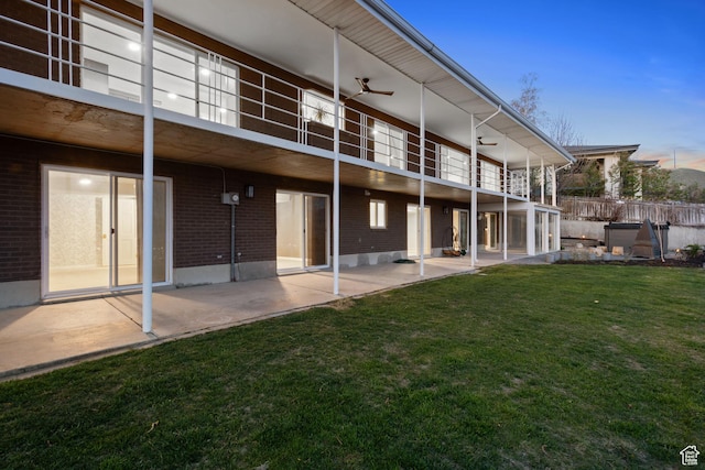 816 E 16th Ave, Salt Lake City, UT 84103 - back of property featuring fence, brick siding, a balcony, a lawn, and a patio