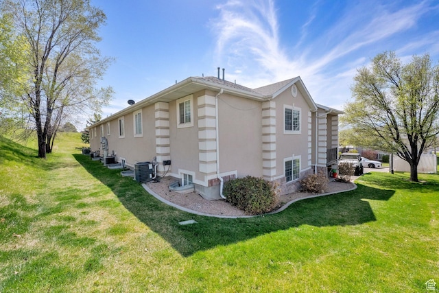 view of property exterior with a yard, central AC unit, and stucco siding