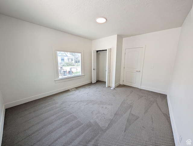 unfurnished bedroom featuring a closet, carpet, visible vents, and baseboards