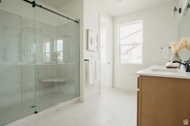 full bathroom featuring vanity, a marble finish shower, baseboards, and plenty of natural light