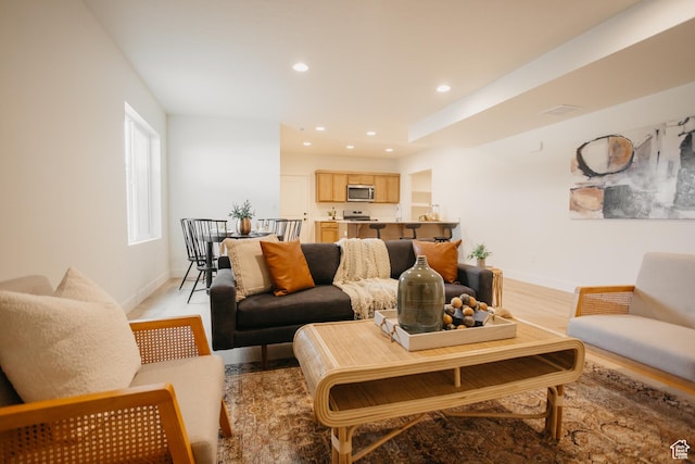 living area with light wood-type flooring, baseboards, and recessed lighting