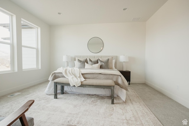 bedroom with visible vents, baseboards, multiple windows, and carpet