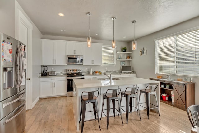 9452 S Alane Hollow Rd W, West Jordan, UT 84081 - kitchen with light wood-type flooring, a kitchen breakfast bar, and appliances with stainless steel finishes