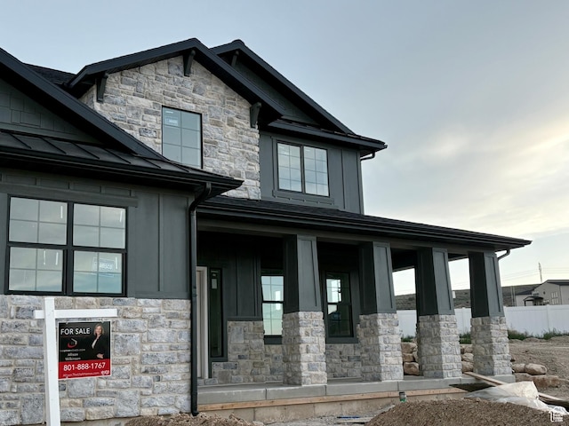 341 N Barlow Ct, Saratoga Springs, UT 84045 - view of front of property featuring stone siding, board and batten siding, a standing seam roof, a porch, and metal roof