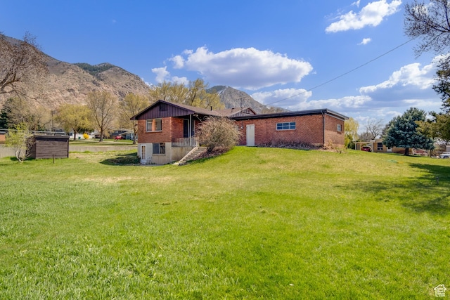 1520 Rushton St, Ogden, UT 84401 - back of house featuring brick siding, a mountain view, and a lawn