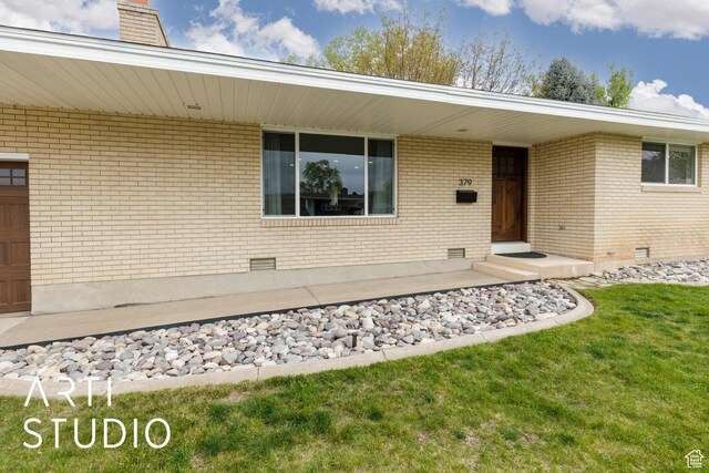 379 E 100 S, Kaysville, UT 84037 - view of exterior entry with a lawn, brick siding, a chimney, and crawl space