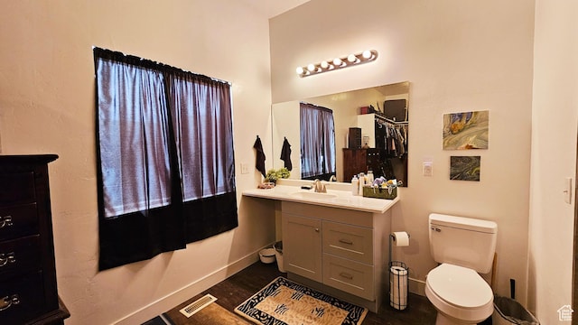 1018 N 3500 W, Vernal, UT 84078 - bathroom with vanity, baseboards, toilet, visible vents, and wood finished floors