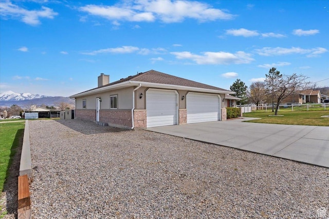 14883 S 3200 W, Bluffdale, UT 84065 - view of side of property featuring a mountain view, an attached garage, a chimney, brick siding, and driveway