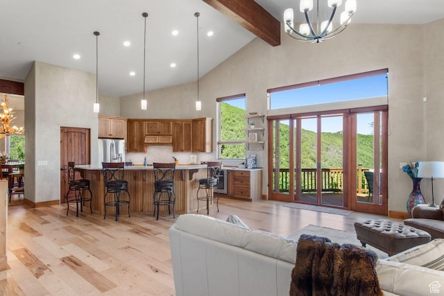 living area with high vaulted ceiling, an inviting chandelier, light wood-type flooring, wine cooler, and beam ceiling